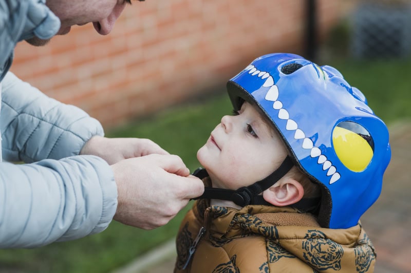 Snapping up a helmet on a child.